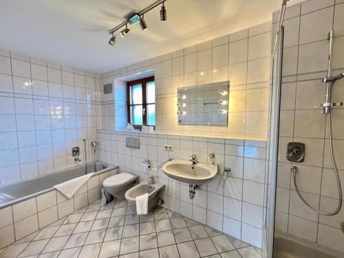 a bathroom with a toilet and a sink and a tub at Ferienhaus Kenzenkopf in Halblech