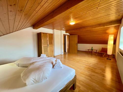 a bedroom with a white bed and a wooden ceiling at Ferienhaus Kenzenkopf in Halblech
