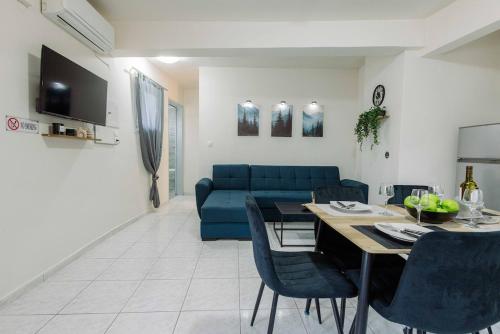 a living room with a blue couch and a table at The Calm City Escape in Heraklio