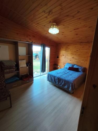 a bedroom with a bed in a wooden cabin at Maranata House in Xuí