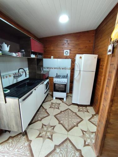a kitchen with a white refrigerator and a tile floor at Maranata House in Xuí