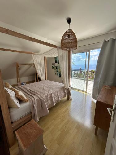 a bedroom with a bed and a large window at Villa Annaga in Saint-Paul