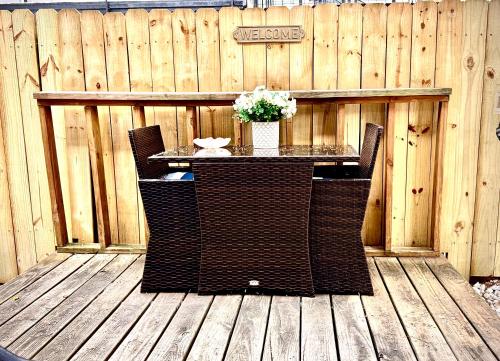 a table and chairs on a wooden deck with a fence at Spotless Full Sized Apartment! Montrose Stays An Art Lover's Dream in Houston