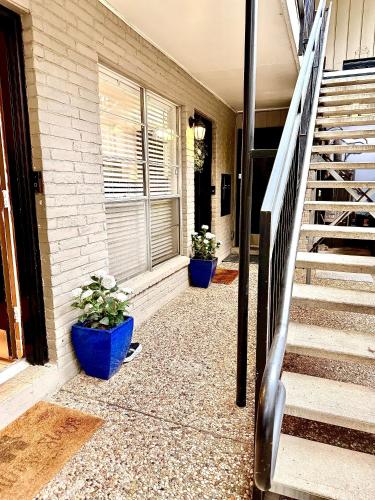 two potted plants sitting on the side of a house at Spotless Full Sized Apartment! Montrose Stays An Art Lover's Dream in Houston