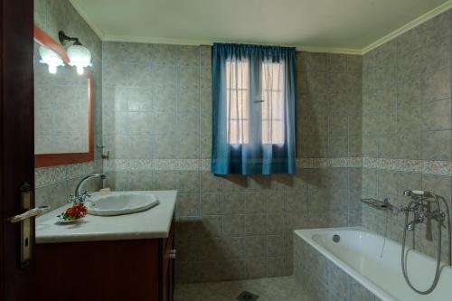 a bathroom with a tub and a sink and a bath tub at Iliopetra in Douliana