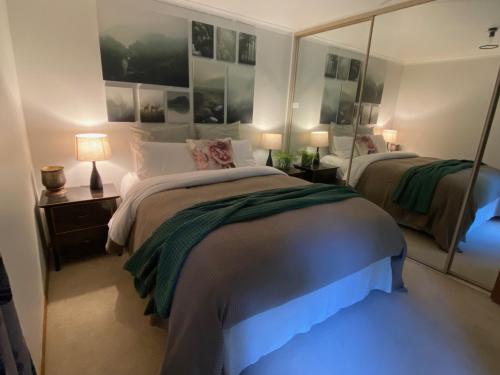 a bedroom with two beds and a large mirror at Botanica Retreat Garden Cabin in Olinda in Olinda