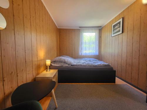 a small bedroom with a bed and a window at Domek Dębowy in Brzozie