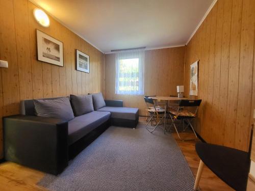 a living room with a couch and a table at Domek Dębowy in Brzozie