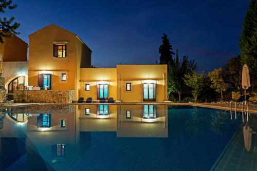 a villa with a swimming pool at night at Iliopetra in Douliana