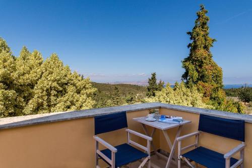 a table and chairs on a balcony with a view at Iliopetra in Douliana