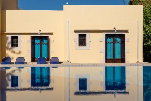 a building with chairs and a swimming pool at Iliopetra in Douliana