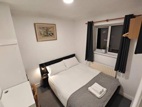 a small bedroom with a bed and a window at Small Compact Self Contained Studio Flat in Oxford