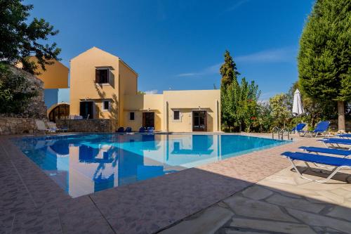 a villa with a swimming pool in front of a house at Iliopetra in Douliana