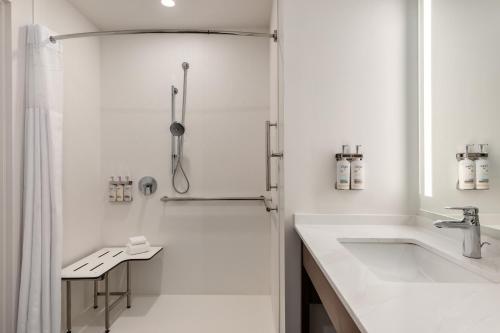 a white bathroom with a shower and a sink at Staybridge Suites Norfolk Airport by IHG in Norfolk