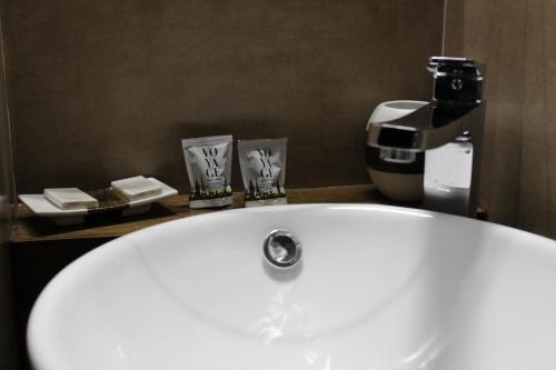La salle de bains est pourvue d'un lavabo blanc et d'une cafetière. dans l'établissement La Cupola Suite, à Rome