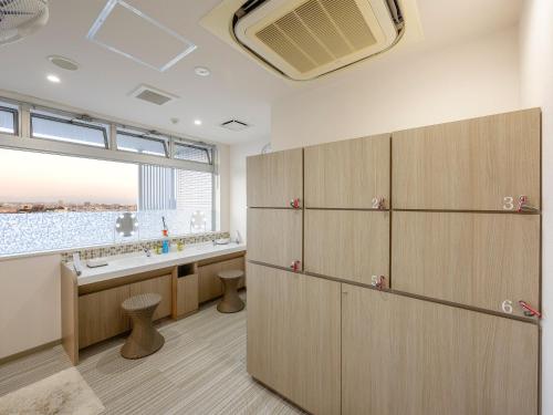 a bathroom with wooden cabinets and a large window at Hotel Meijiya in Hamamatsu
