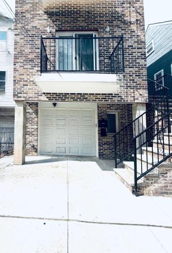 a brick house with a garage and a balcony at Temperly Heavon in Newark