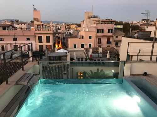 a swimming pool on the roof of a building at Petit Palace Hotel Tres in Palma de Mallorca