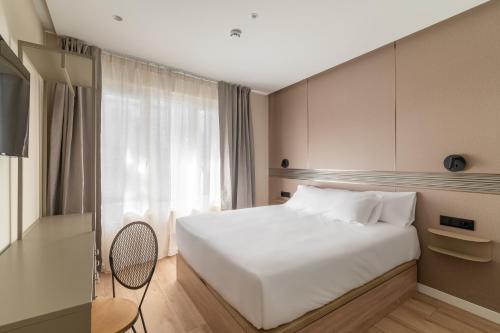 a bedroom with a white bed and a window at LEE Hotel in Andorra la Vella
