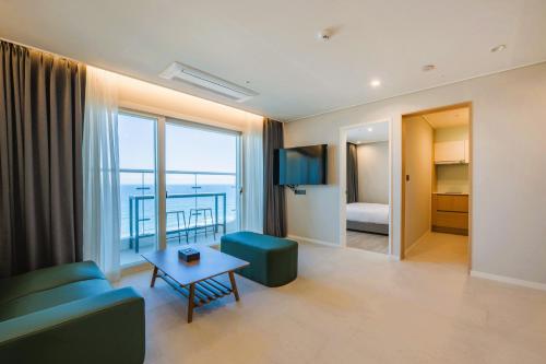 a living room with a couch and a table at Chestertons Naksan in Yangyang