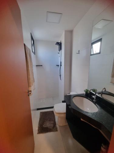 a bathroom with a sink and a toilet and a mirror at Studio Proximo Anashopping Kitnet 101 in Anápolis