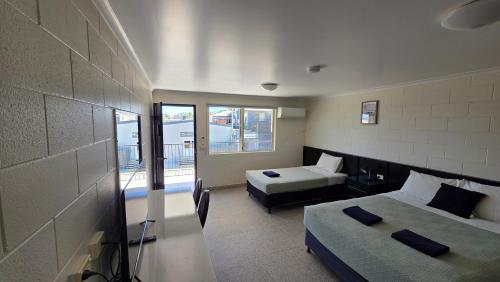 a hotel room with two beds and a balcony at Longreach Most Central Motel in Longreach