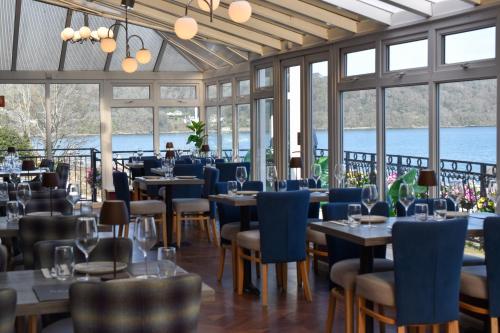 a restaurant with tables and chairs and windows at Nomi Rooms & Restaurant in Bangor