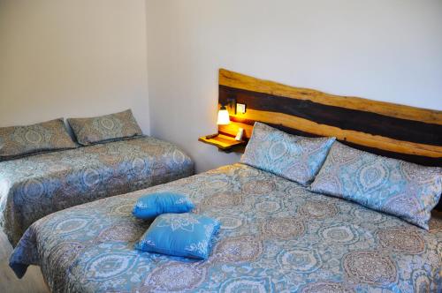 a bedroom with two beds with blue pillows at Villa Eva Luxury Akumal in Akumal