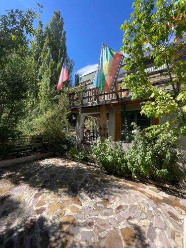 a house with flags on the side of it at Hostal Crisol in Refugio Lo Valdés