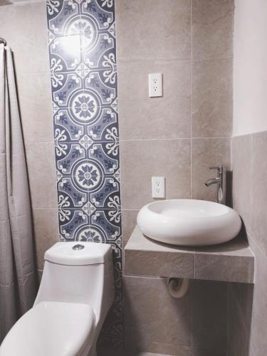 a bathroom with a white toilet and a sink at Casa Altita Accommodation in Zacatlán