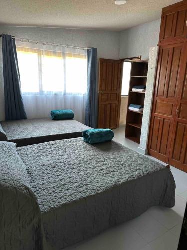 a bedroom with two beds and a window at Casa Altita Accommodation in Zacatlán