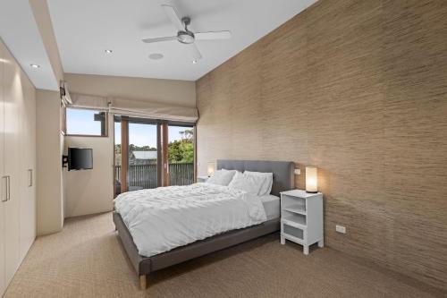 a bedroom with a bed and a brick wall at Kingsley in Point Lonsdale