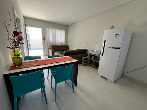 a kitchen with a dining table and a refrigerator at Residenc Mazonetto in Primavera do Leste
