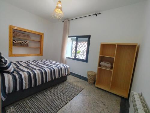 a bedroom with a bed and a window at Apartment amina in Azrou