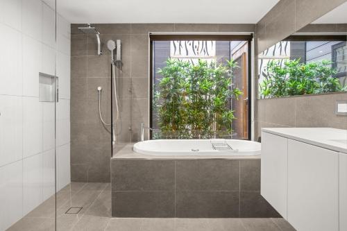 a bathroom with a shower and a sink and a tub at Albertine House in Melbourne
