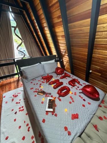 a bed covered in red hearts on a white blanket at Chalé das Laranjeiras in Planalto