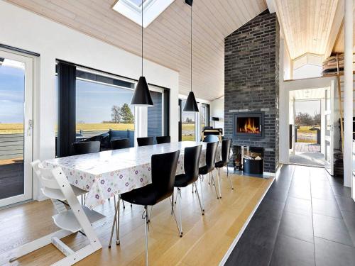 a dining room with a table and chairs and a fireplace at Coastal Home with Spa and Sauna in Spodsbjerg