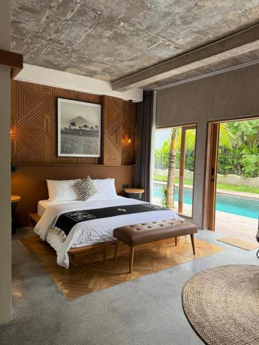 a bedroom with a large bed and a pool at Koji Collection in Kerobokan