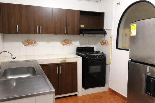 a small kitchen with a stove and a sink at Edificio AREAS by QuBeLab in Bello