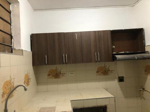 a bathroom with brown cabinets and a tiled floor at Edificio AREAS by QuBeLab in Bello