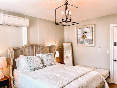 a bedroom with a large bed with a chandelier at Buttonwood Hotel 1 - Boutique Accommodations in Cape May
