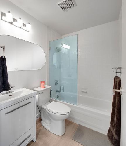 a bathroom with a toilet and a glass shower at City Centre Studio - Best Location! in Vancouver
