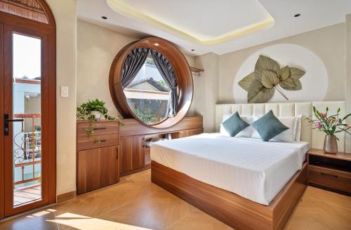 a bedroom with a bed and a round mirror at Jan Casa in Ho Chi Minh City