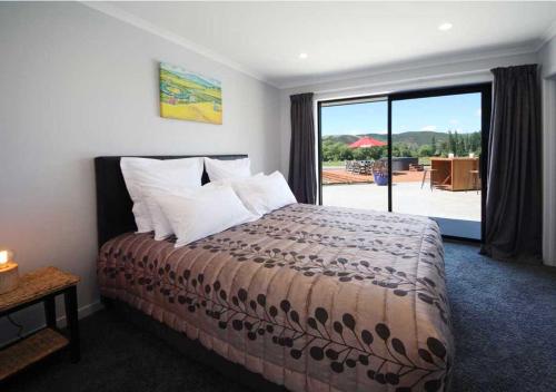 a bedroom with a bed with a view of a patio at Mata-au Lodge in Beaumont