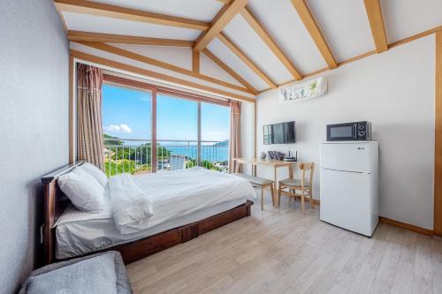 a bedroom with a bed and a large window at Muuido Haedungsil Pension in Incheon