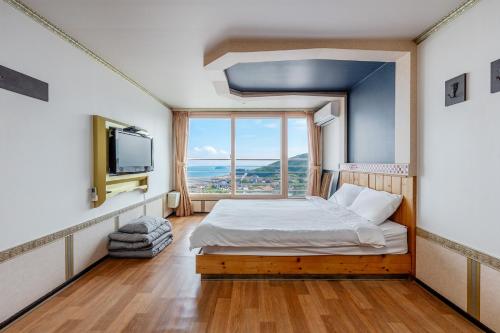 a bedroom with a bed and a large window at Muuido Haedungsil Pension in Incheon