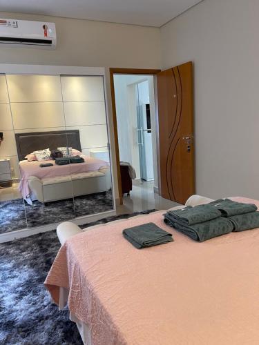 a bedroom with two beds and a large mirror at Lilly Queen I in Londrina
