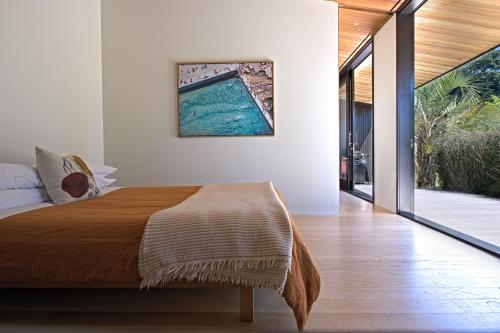 a bedroom with a bed and a view of a pool at Hot Water Beach Bure Wera in Hotwater Beach