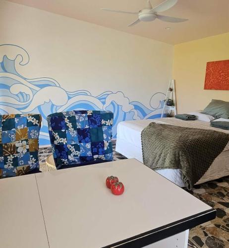 a bedroom with two beds and a red rose on a bench at Vinita Villas in Ngatangiia