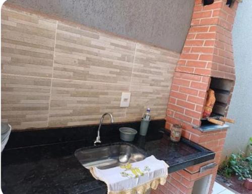 a kitchen with a sink and a brick oven at Espaço amplo e privativo in Trindade